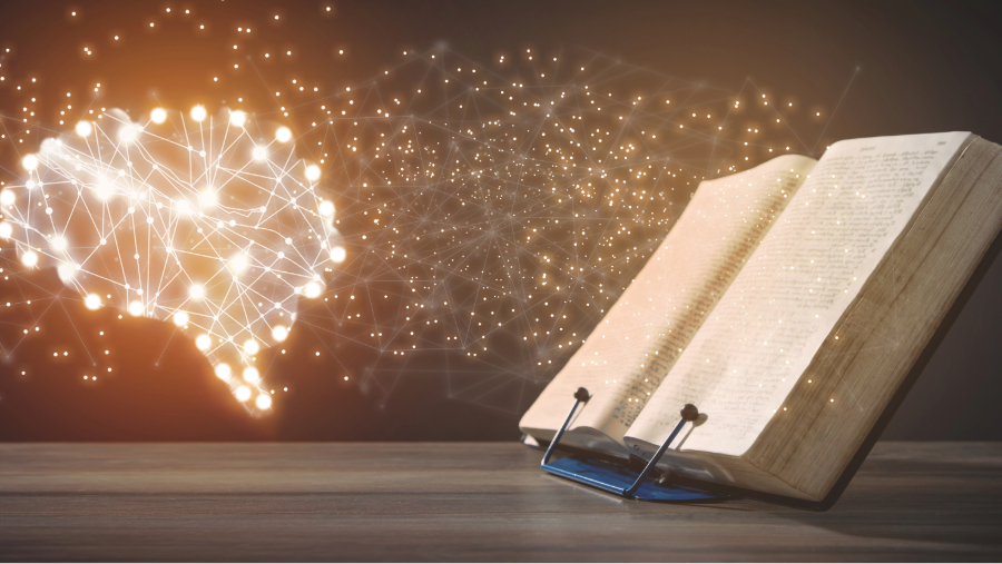 Otwarta książka na drewnianym stole emitująca światło z połączonymi punktami tworzącymi mapę świata, symbolizująca globalne połączenie wiedzy sztucznej inteligenncji w marketingu i nauki.